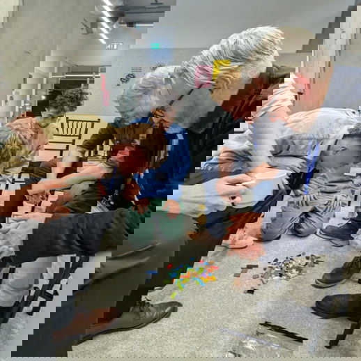 Photo of 2i team members working together to solve a puzzle